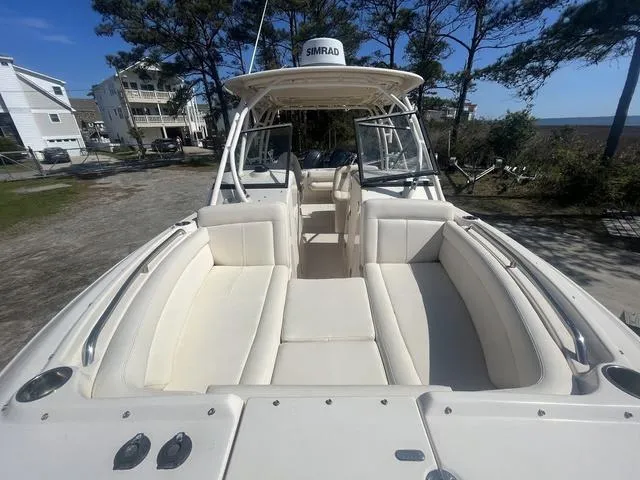 Slide: The Image of 2016 Grady-White Freedom 275 boat with spacious seating, docked near coastal homes and trees. - 7