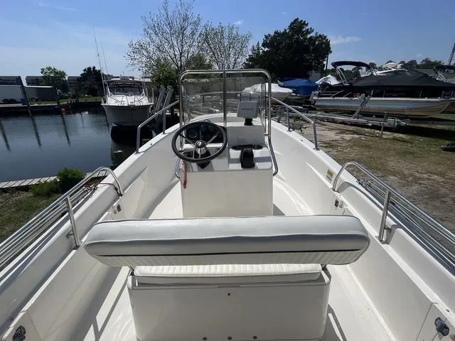 Slide: The Image of 1999 Boston Whaler 160 Dauntless boat interior with steering wheel, docked near other boats. - 12
