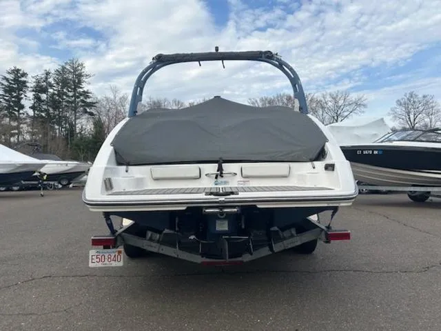 Slide: The Image of 2018 Yamaha Boats 242 Limited S, covered, parked on a trailer in a marina. - 5