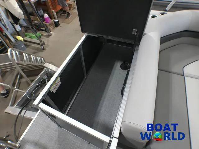 Slide: The Image of 2025 Princecraft Vectra 21 Cruise Lounge storage compartment, open, with gray seating and Boat World logo. - 18
