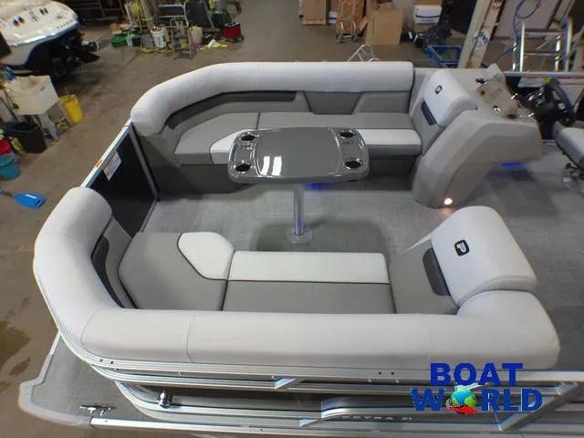 Slide: The Image of 2025 Princecraft Vectra 21 Cruise Lounge interior with plush seating and table, in a showroom. - 3