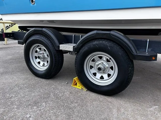 Slide: The Image of Trailer wheels of a 2021 Bayliner VR6 Bowrider, secured with a yellow wheel chock. - 4