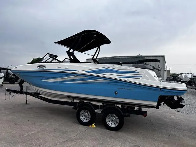 Slide: The Image of 2021 Bayliner VR6 Bowrider boat on trailer, blue and white design, parked outdoors. - 5