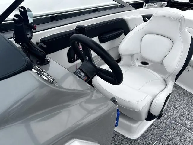 Slide: The Image of 2018 Chaparral 21 H2O Sport I/O boat interior with steering wheel and white captain's chair. - 15