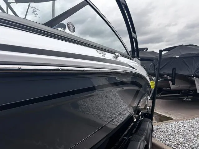 Slide: The Image of 2018 Chaparral 21 H2O Sport I/O boat, sleek black exterior, parked on gravel. - 3
