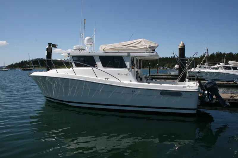 Slide: The Image of 2011 Ocean Sport Roamer 30' boat docked in a serene marina setting. - 1