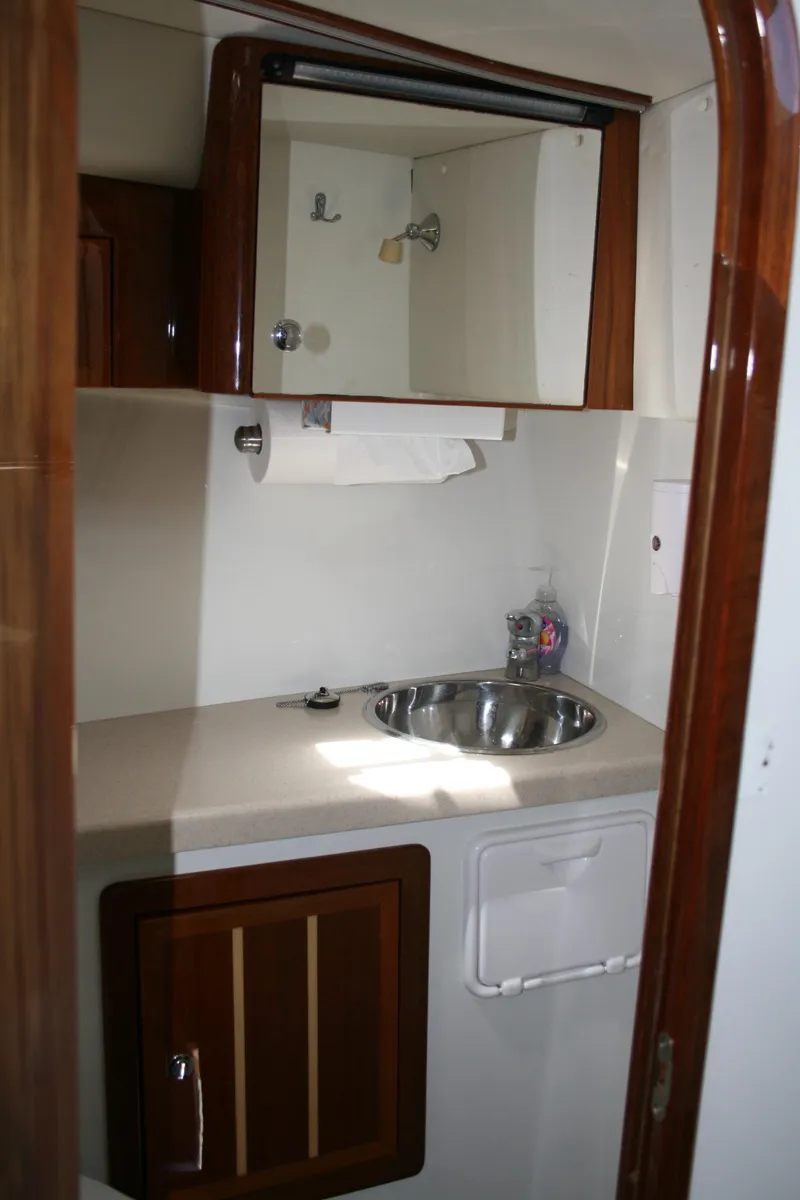 Slide: The Image of 2011 Ocean Sport Roamer 30' bathroom with sink, mirror, and wooden cabinetry. - 15