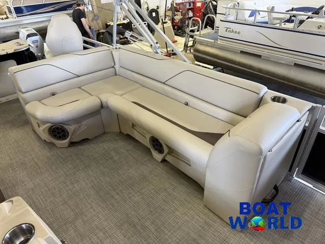Slide: The Image of 2025 Tahoe Sport 2185 Quad Fish boat interior with beige seating and speakers at Boat World. - 14