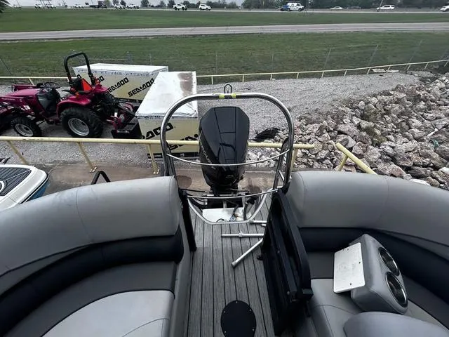 Slide: The Image of 2020 Lowe SS250 WS WindShield boat interior with seating and motor, parked near a tractor. - 14