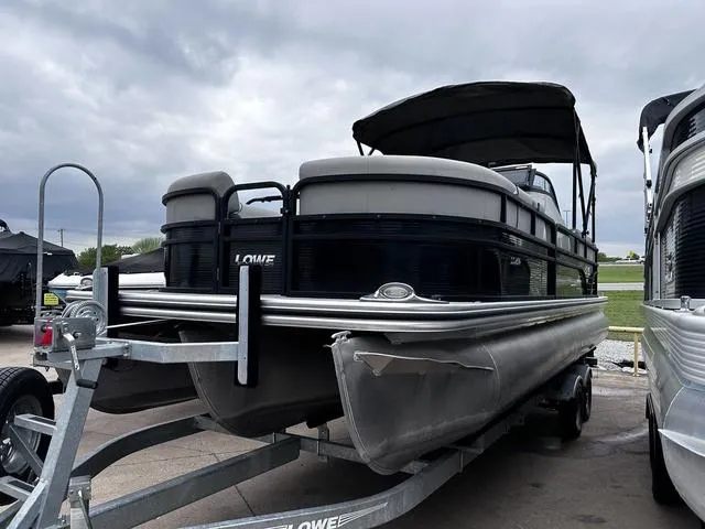 Slide: The Image of 2020 Lowe SS250 WS WindShield pontoon boat on trailer, under cloudy sky. - 7