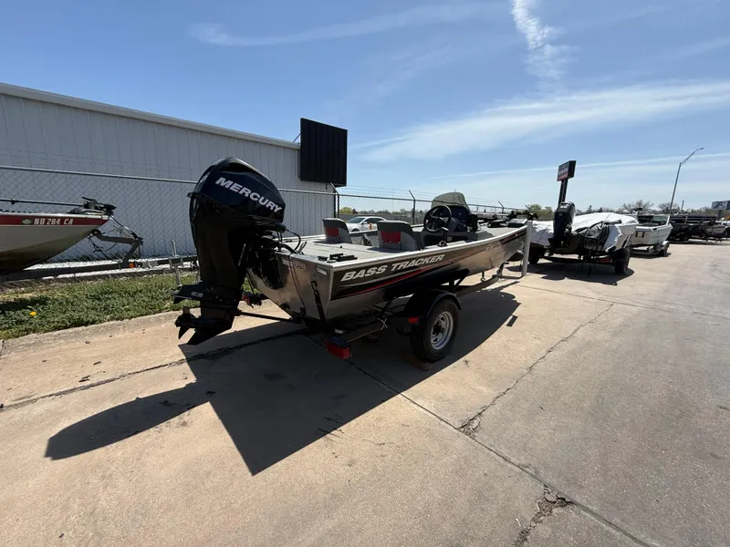 Slide: The Image of 2011 Tracker Pro 165 boat with Mercury engine on a trailer, parked outdoors. - 2