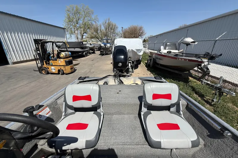 Slide: The Image of 2011 Tracker Pro 165 boat with dual seats, parked near other boats and a forklift. - 9