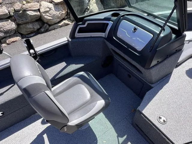 Slide: The Image of 2023 Lund 1775 Impact XS Sport boat interior with gray seating and dashboard. - 11