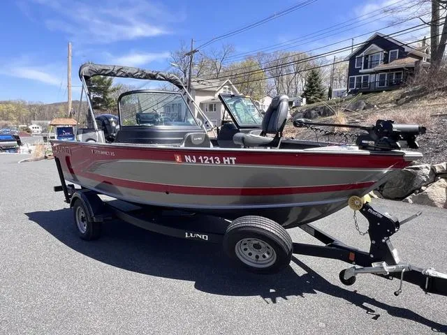 Slide: The Image of 2023 Lund 1775 Impact XS Sport boat on trailer, parked outdoors. - 9