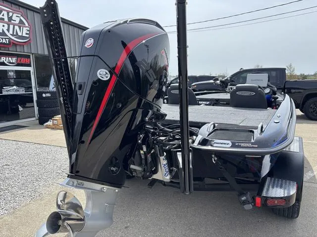 Slide: The Image of 2025 Phoenix 920 Elite boat with powerful outboard motor, parked at a marina. - 2
