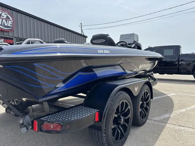 Slide: The Image of 2025 Phoenix 920 Elite boat with sleek design and dual-axle trailer in parking lot. - 3