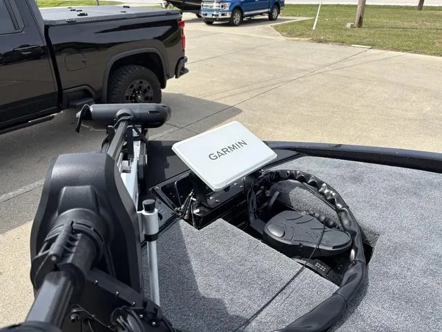 Slide: The Image of 2025 Phoenix 920 Elite boat with Garmin navigation system, parked near black and blue trucks. - 9