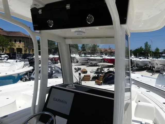 Slide: The Image of 2025 Key West 239 FSR boat interior with Garmin navigation, surrounded by other boats. - 13
