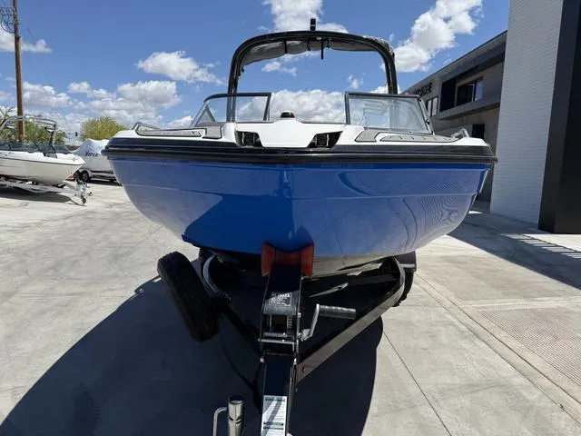 Slide: The Image of 2017 Yamaha Boats AR210 on trailer, blue hull, parked outdoors under clear sky. - 3