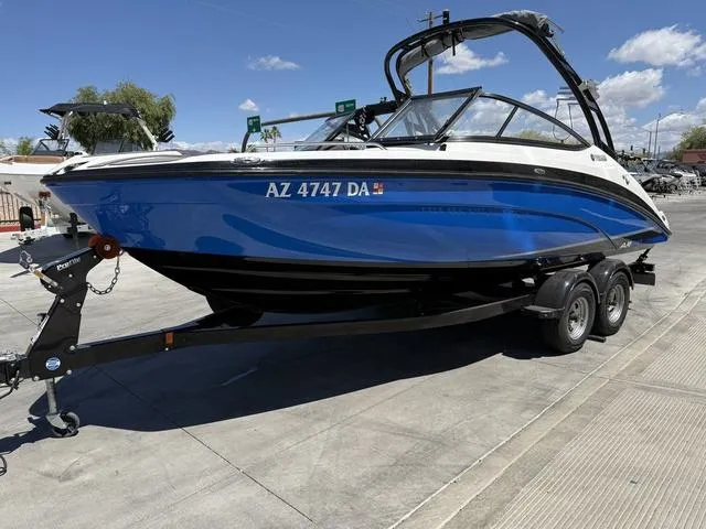 Slide: The Image of 2017 Yamaha AR210 boat on trailer, blue and white, parked outdoors. - 4