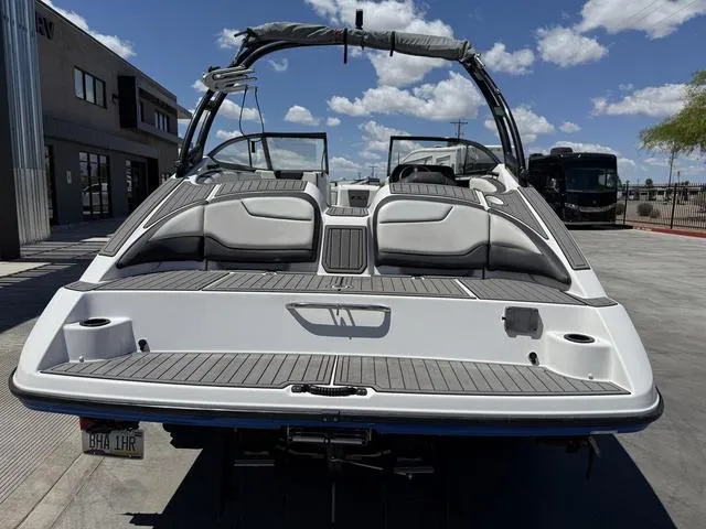 Slide: The Image of 2017 Yamaha AR210 boat, rear view, parked outdoors under a clear blue sky. - 7