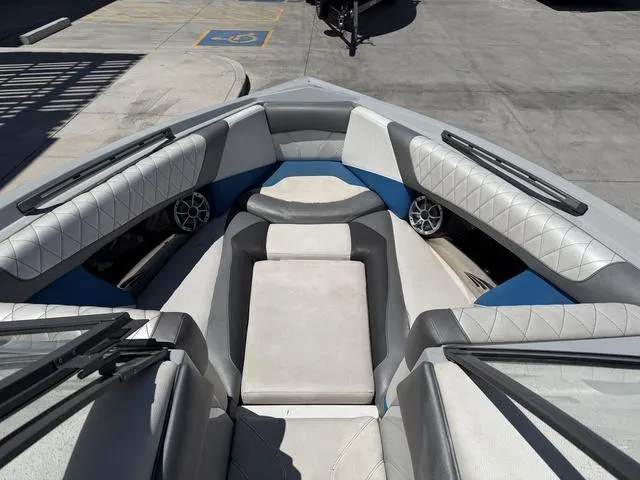 Slide: The Image of 2015 Tigé Z3 boat interior with cushioned seating and speakers, parked in a concrete area. - 10