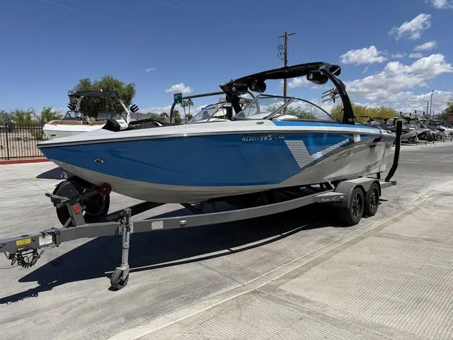Slide: The Image of 2015 Tigé Z3 boat on trailer, blue and white, parked outdoors under clear sky. - 4