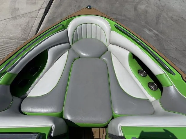 Slide: The Image of 2016 Sanger 215S boat interior with green and gray cushioned seating. - 10