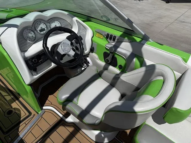 Slide: The Image of Cockpit of 2016 Sanger 215S boat with green and white interior design. - 11