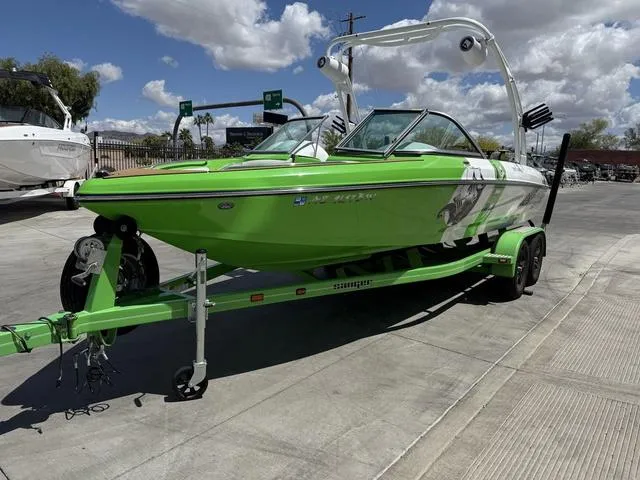 Slide: The Image of Green 2016 Sanger 215S boat on trailer under cloudy sky. - 4