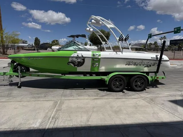 Slide: The Image of 2016 Sanger 215S boat in green and white on a trailer, parked outdoors. - 5
