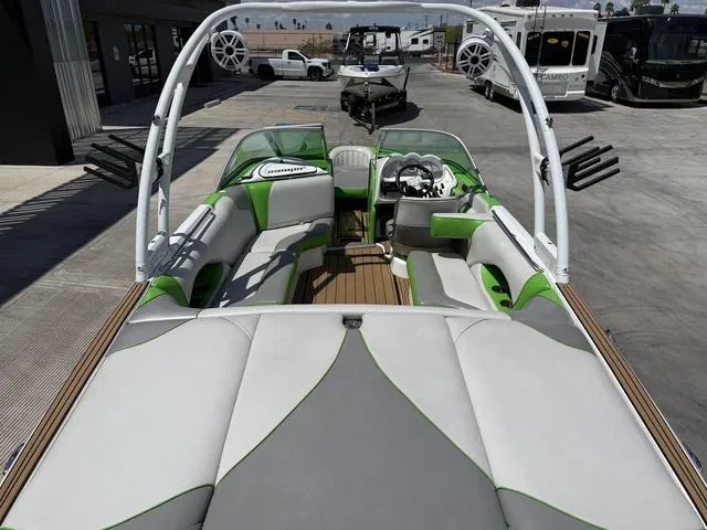 Slide: The Image of 2016 Sanger 215S boat interior with green and gray seating, tower speakers, and steering console. - 9