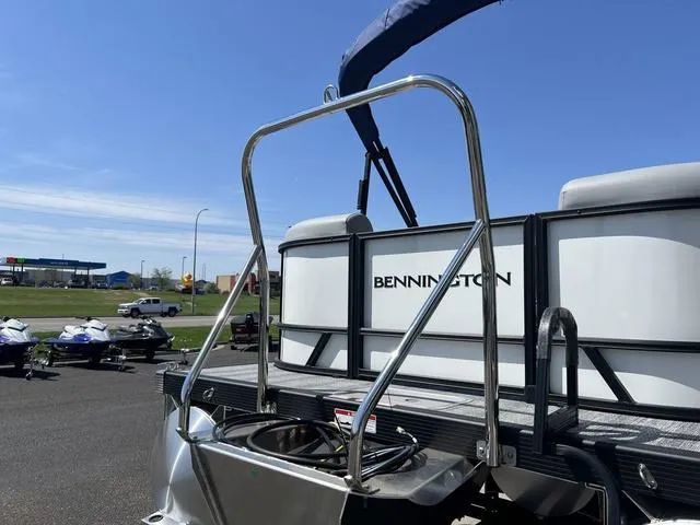 Slide: The Image of 2025 Bennington 22 SSR PTG pontoon boat with stainless steel railing, parked outdoors. - 4