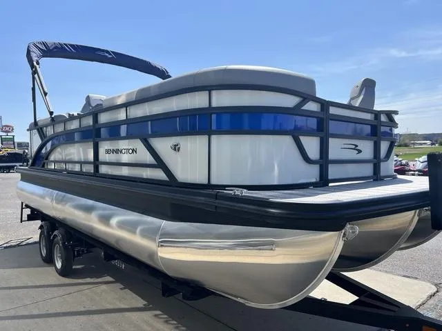 Slide: The Image of 2025 Bennington 22 SSR PTG pontoon boat on trailer, side view under clear sky. - 6