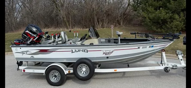 Slide: The Image of 2003 Lund 2025 Pro-V Magnum SE fishing boat on trailer, parked outdoors. - 1
