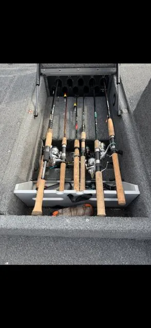 Slide: The Image of Fishing rods stored in a 2003 Lund 2025 Pro-V Magnum SE boat compartment. - 11