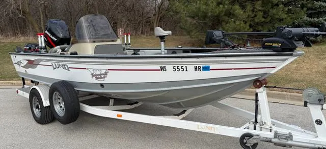 Slide: The Image of 2003 Lund 2025 Pro-V Magnum SE boat on trailer, parked outdoors. - 14
