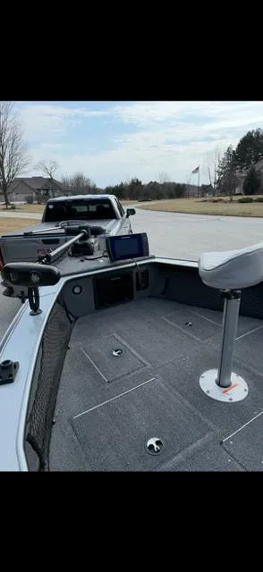 Slide: The Image of 2003 Lund 2025 Pro-V Magnum SE boat with fishing seat and equipment on a driveway. - 6