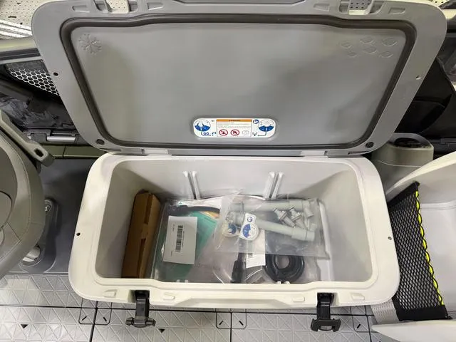 Slide: The Image of Open storage compartment on 2025 Sea-Doo Switch™ Fish 18, showing various accessories and equipment. - 19