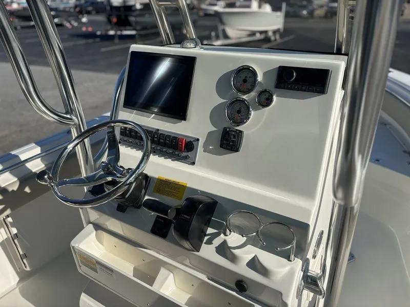 Slide: The Image of 2025 Key West 219 FS boat dashboard with steering wheel, gauges, and electronic display. - 11