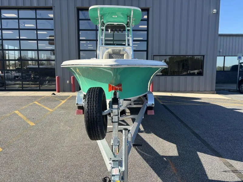 Slide: The Image of 2025 Key West 219 FS boat on trailer, parked outside a modern building. - 6