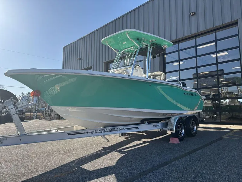 Slide: The Image of 2025 Key West 219 FS boat on trailer, parked outside a building. - 7