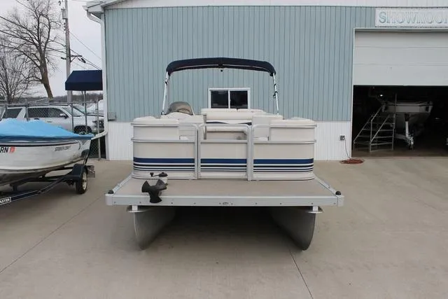Slide: The Image of 2002 Harris Cruiser 200 pontoon boat parked outside a blue building. - 4