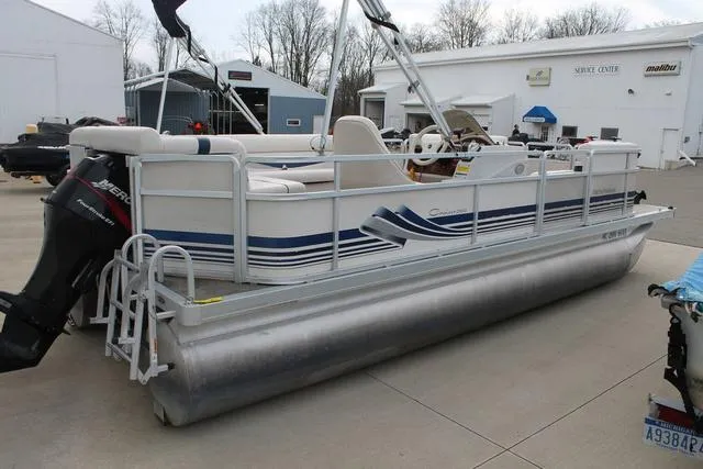 Slide: The Image of 2002 Harris Cruiser 200 pontoon boat parked at a marina with outboard motor. - 6