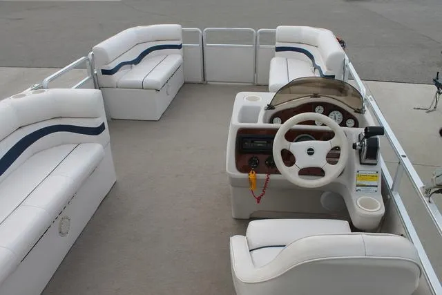 Slide: The Image of Interior of a 2002 Harris Cruiser 200 pontoon boat with white seating and steering console. - 9