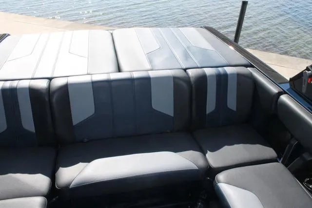 Slide: The Image of 2023 Malibu 21 LX boat interior with stylish seating near water. - 11