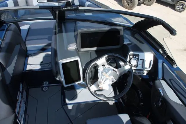 Slide: The Image of 2023 Malibu 21 LX boat dashboard with modern controls and steering wheel. - 14