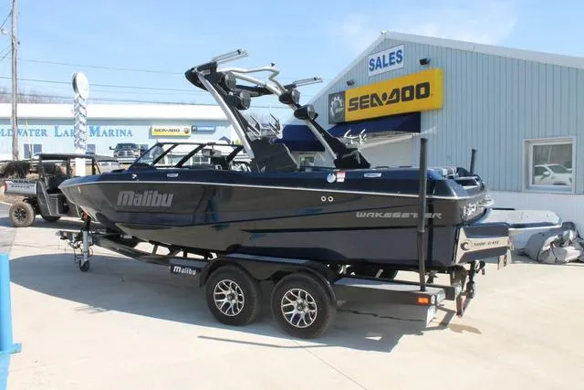 Slide: The Image of 2023 Malibu 21 LX boat on trailer at dealership, featuring sleek design and modern features. - 3
