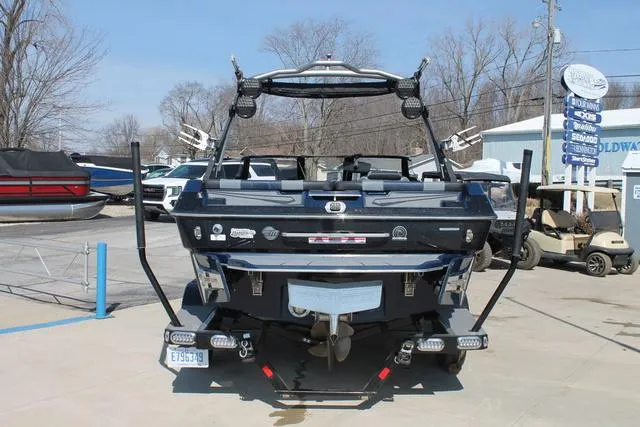 Slide: The Image of 2023 Malibu 21 LX boat, rear view, parked outdoors on a sunny day. - 4