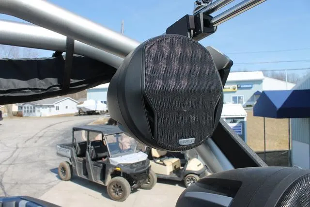 Slide: The Image of 2023 Malibu 21 LX boat speaker system with outdoor vehicles in the background. - 9